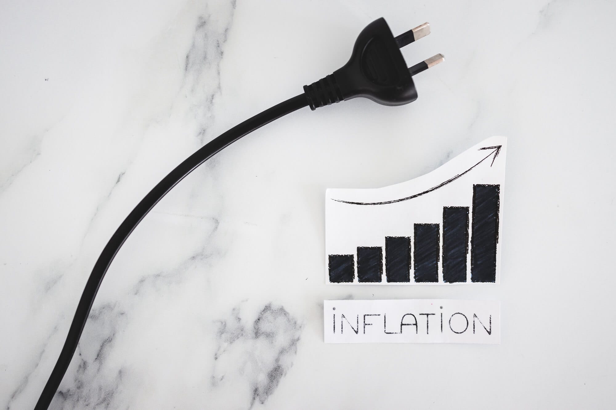 Electricity costs going up ,conceptual image with plug next to stats graph showing prices going up
