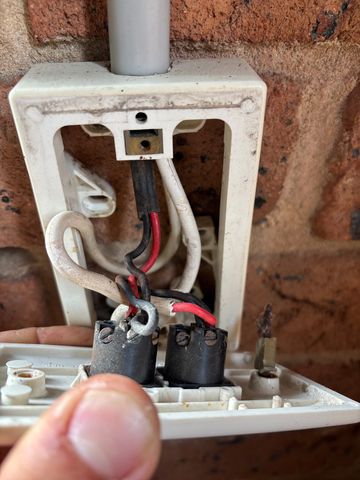Open electrical switch with red, black and white wiring visible.