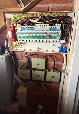 Open residential electrical switchboard with circuit breakers and wiring visible.