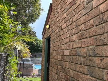 Outdoor wall light mounted on the brick exterior of a house.